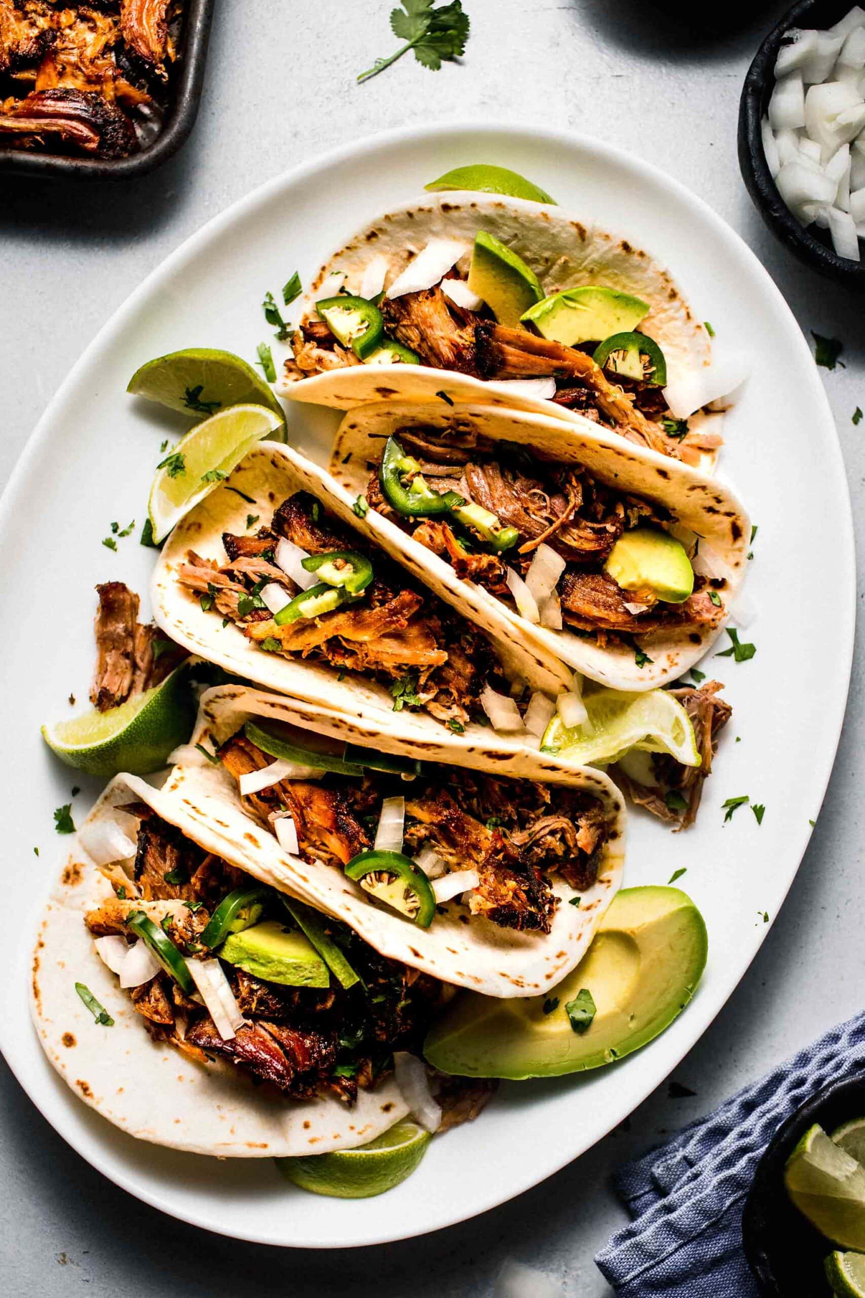 Carnitas tacos arranged on plate.