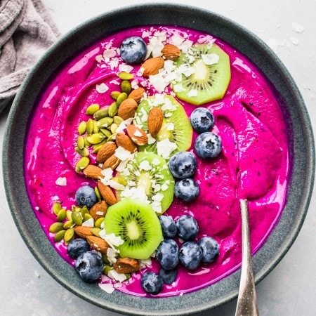 Dragon Fruit Smoothie Bowl topped with blueberries, coconut, almonds, kiwi and pumpkin seeds.