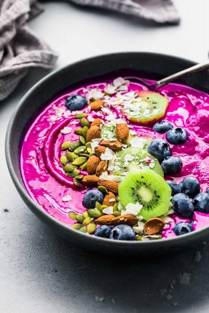 Dragon Fruit Smoothie Bowl topped with blueberries, coconut, almonds, kiwi and pumpkin seeds.