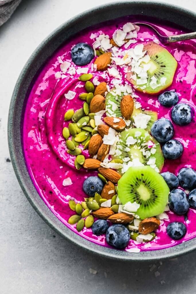 Dragon Fruit Smoothie Bowl topped with blueberries, coconut, almonds, kiwi and pumpkin seeds.