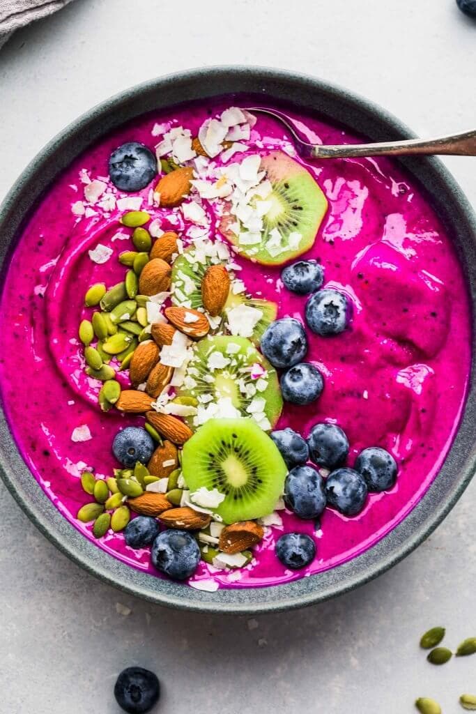 Dragon Fruit Smoothie Bowl topped with blueberries, coconut, almonds, kiwi and pumpkin seeds.