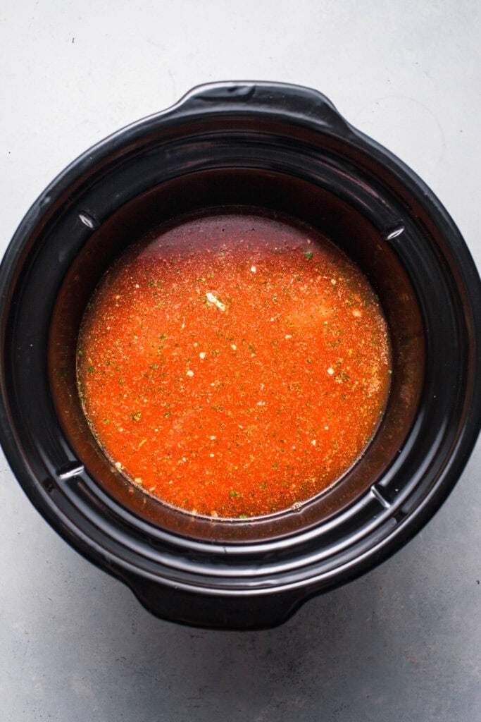 Ingredients added to slow cooker before cooking.