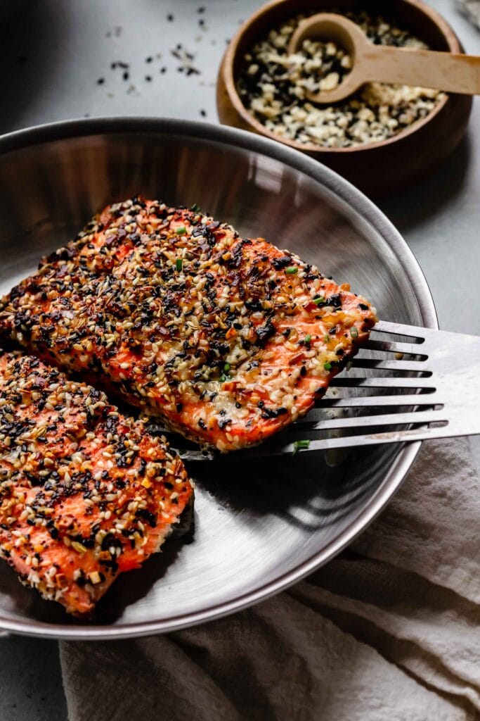 Everything crusted salmon being seared in skillet.