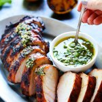 This Grilled Pork Tenderloin with Charred Lemon Chimichurri is the perfect quick dinner for hot summer nights! You can grill this beautiful dinner and prepare the amazing sauce in just 30 minutes. | platingsandpairings.com