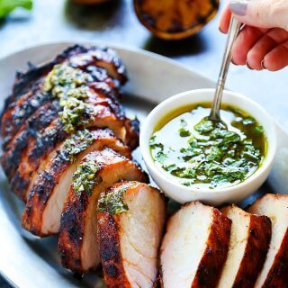This Grilled Pork Tenderloin with Charred Lemon Chimichurri is the perfect quick dinner for hot summer nights! You can grill this beautiful dinner and prepare the amazing sauce in just 30 minutes. | platingsandpairings.com