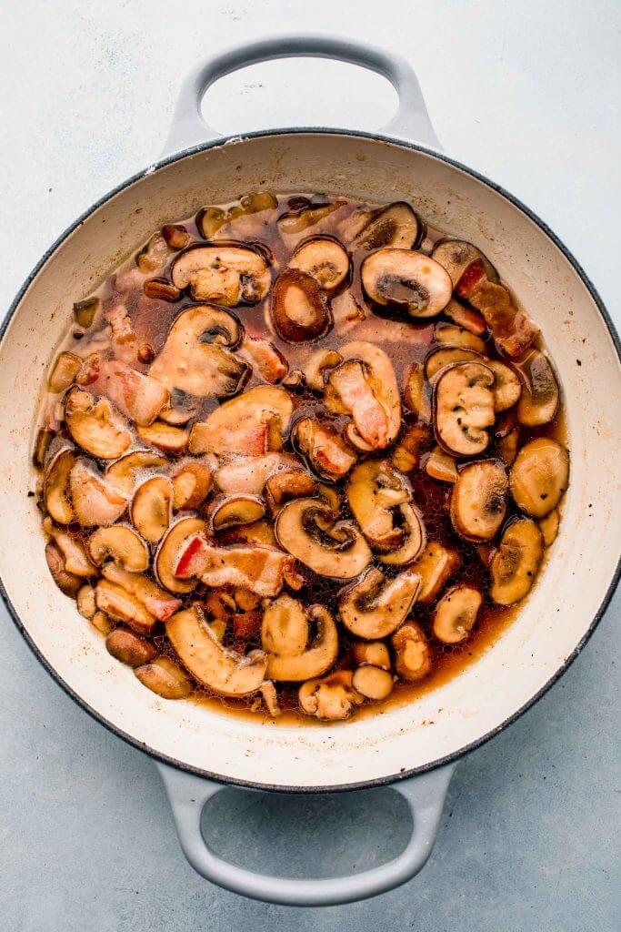 Chicken in skillet with marsala wine, mushrooms and bacon. 