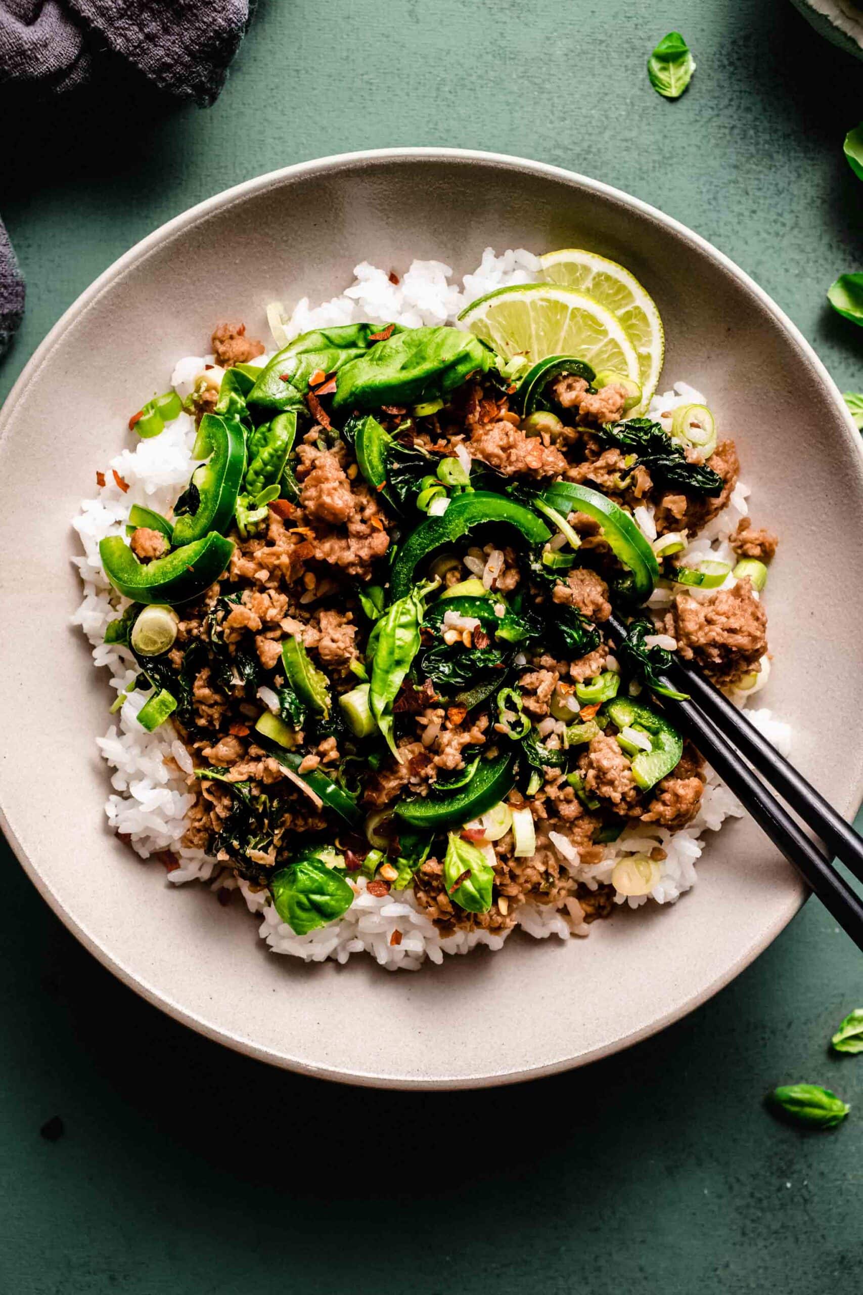 Thai basil beef in bowl with chopsticks.