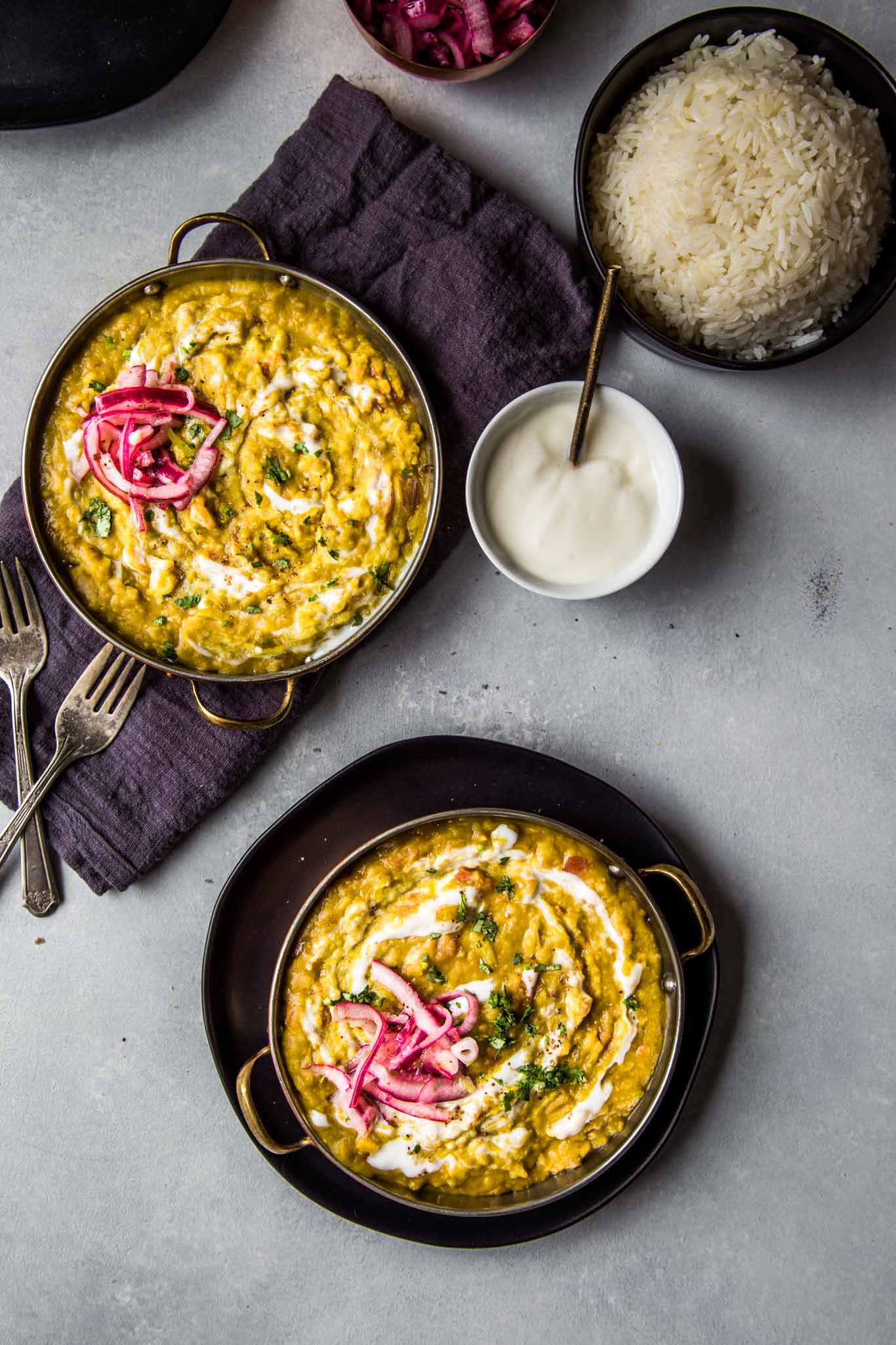 overhead closeup of instant pot split pea dal next to bowl of yogurt and rice