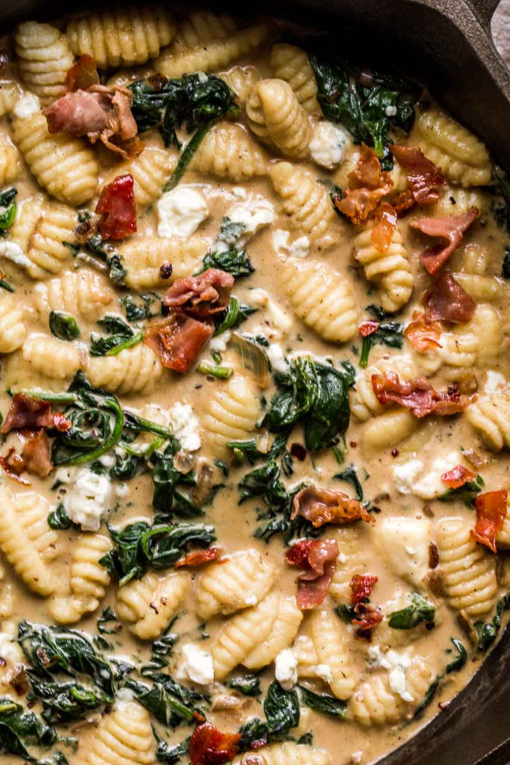 Overhead close up of blue cheese gnocchi tossed with prosciutto and spinach.