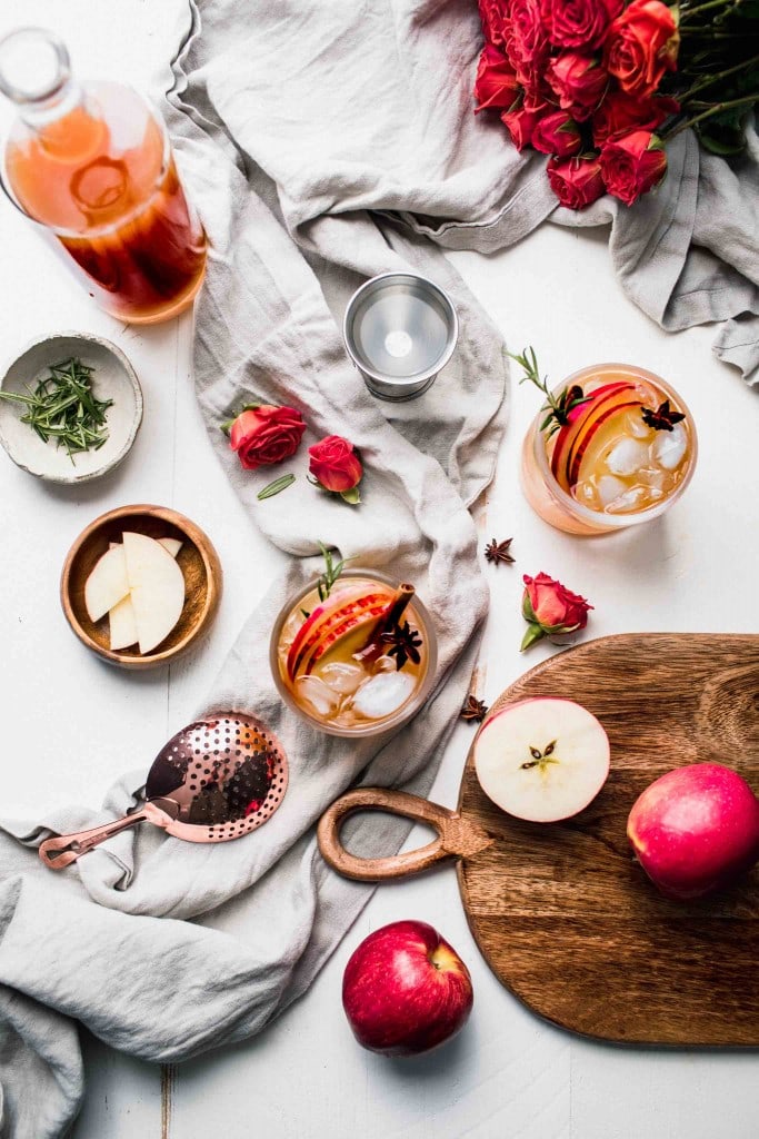 Ingredients for cider cocktail on white counter.