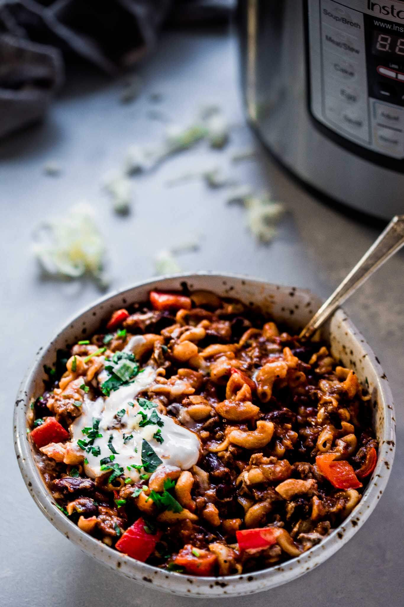 Side view of bowl of chili mac next to Instant Pot.