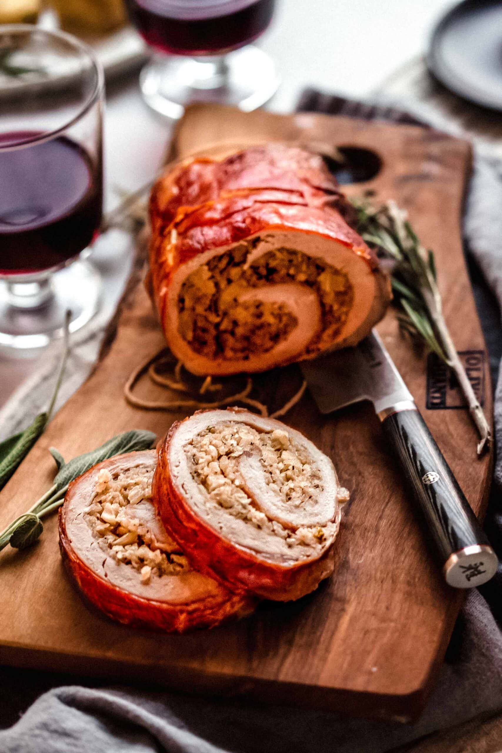 Prosciutto wrapped pork tenderloin sliced in pieces so that you can see the stuffing filling.