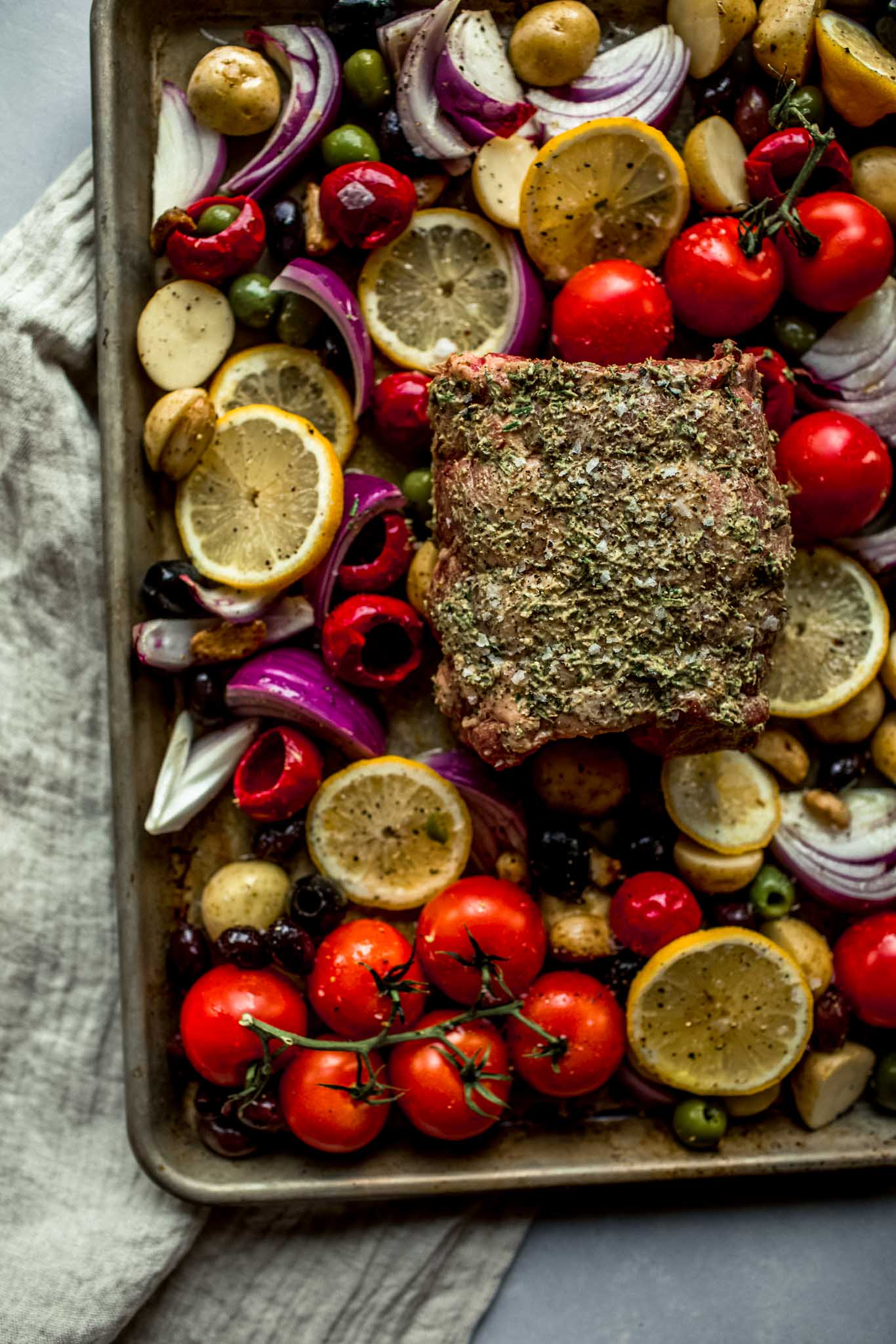 Veggies and olives arranged on sheet pan - topped with lamb before going in oven.
