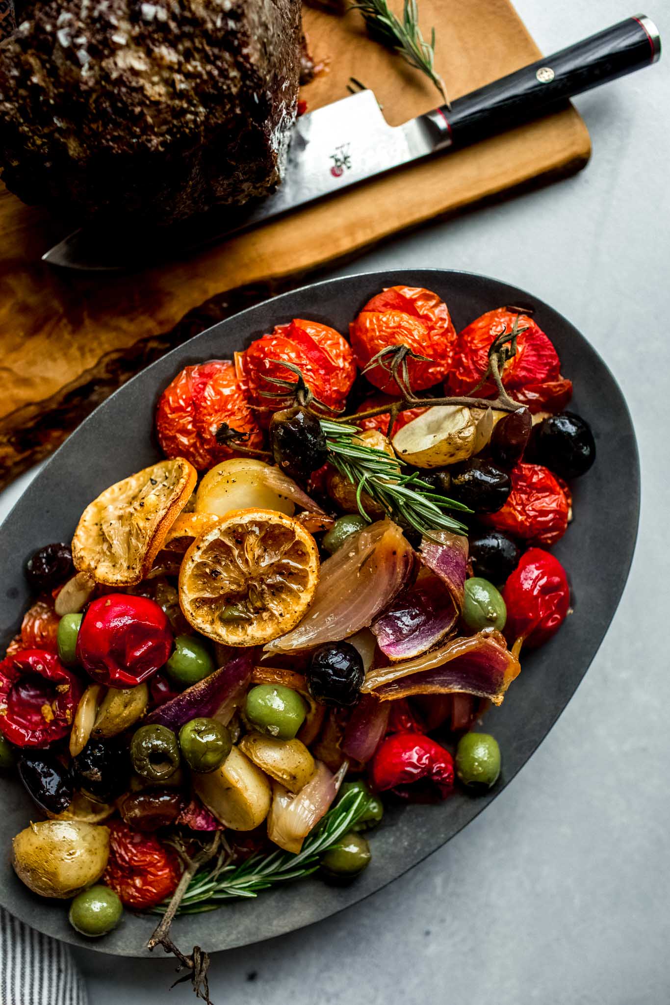 Cooked vegetables and olives on serving platter.