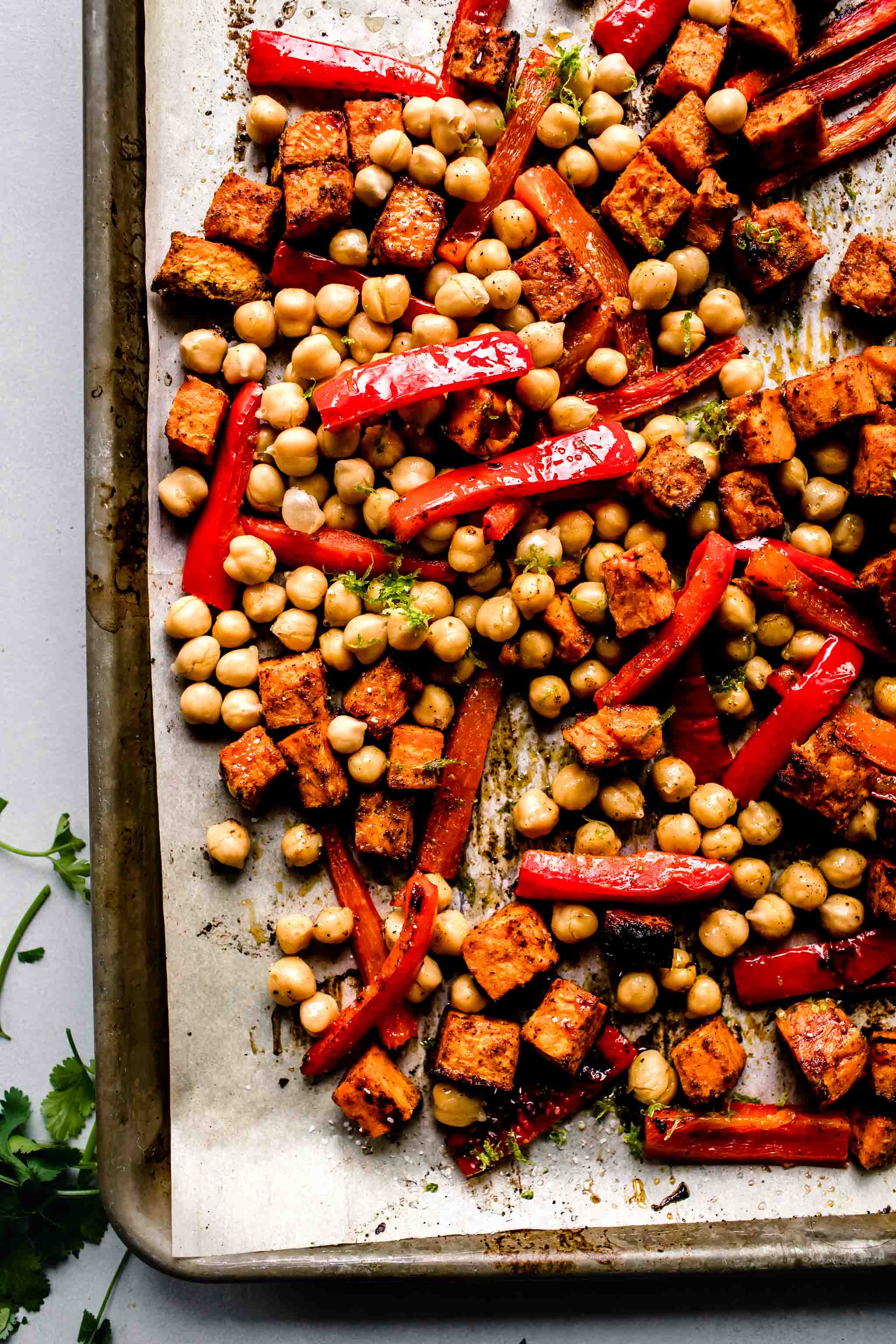 Peppers, sweet potatoes and chickpeas on baking sheet after roasting.