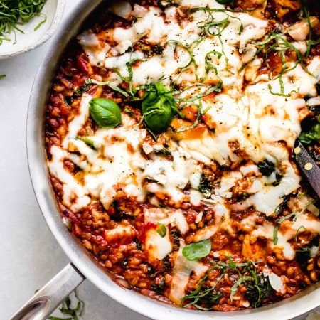 Overhead shot of farro skillet with chicken topped with melted cheese.