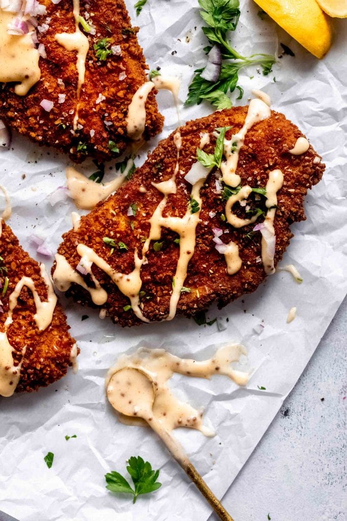 Overhead close up of chicken breast drizzled with cheese sauce.