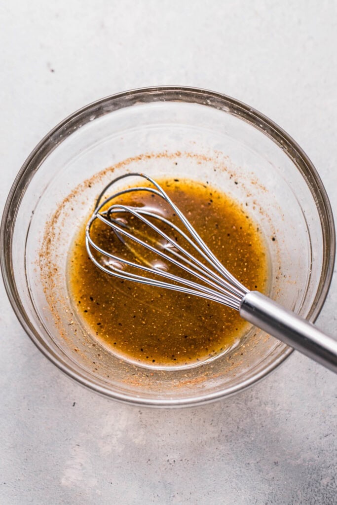 Dressing ingredients whisked together in bowl.