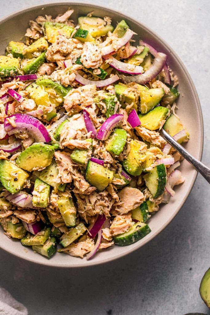 Overhead close up of avocado cucumber tuna salad in serving bowl.