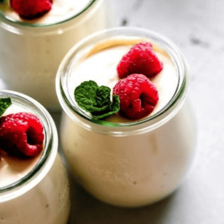 SIDE VIEW OF THREE JARS OF RASPBERRY RICOTTA MOUSSE.