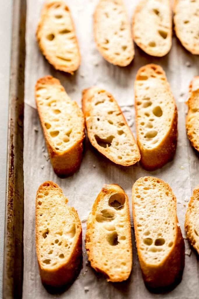 Crostini slices on baking sheet.