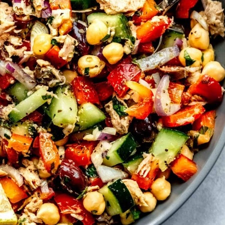 Overhead close up of chickpea tuna salad in grey shallow bowl with spoon.