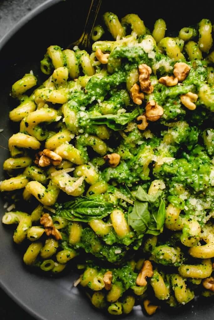 Overhead close up of bowl of pasta tossed with broccoli pesto.
