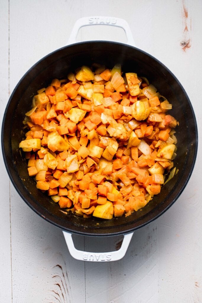 Softened veggies and squash in pot. 