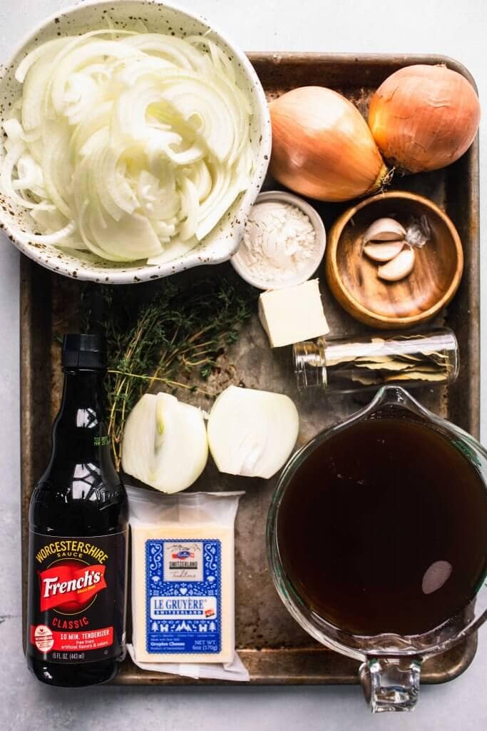 Ingredients for french onion soup laid out on baking sheet.