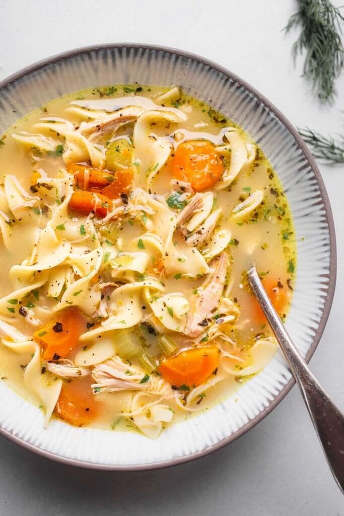 Bow of instant pot chicken noodle soup with spoon. 