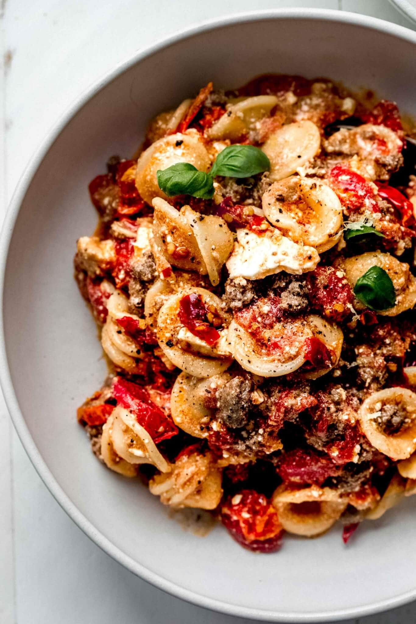Overhead shot of feta pasta in shallow white bowl.
