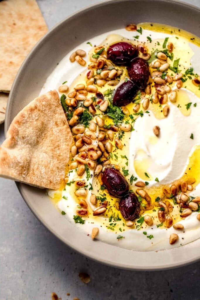 Overhead close up of whipped feta with pita dipped into it.