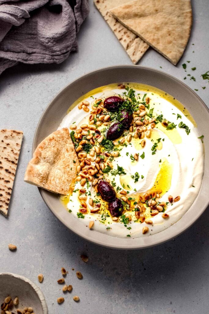 Bowl of whipped feta on counter with pita bread.