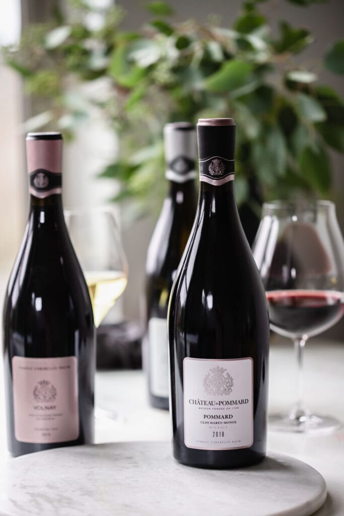 Three bottles of wine on counter.