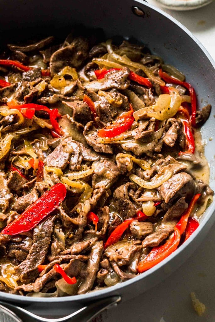 Steak and peppers in skillet.