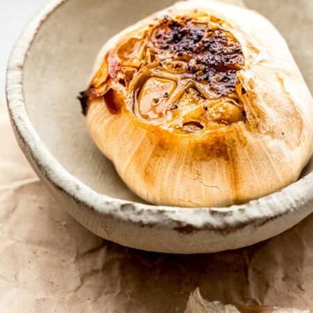 ROASTED GARLIC IN SMALL SERVING DISH.