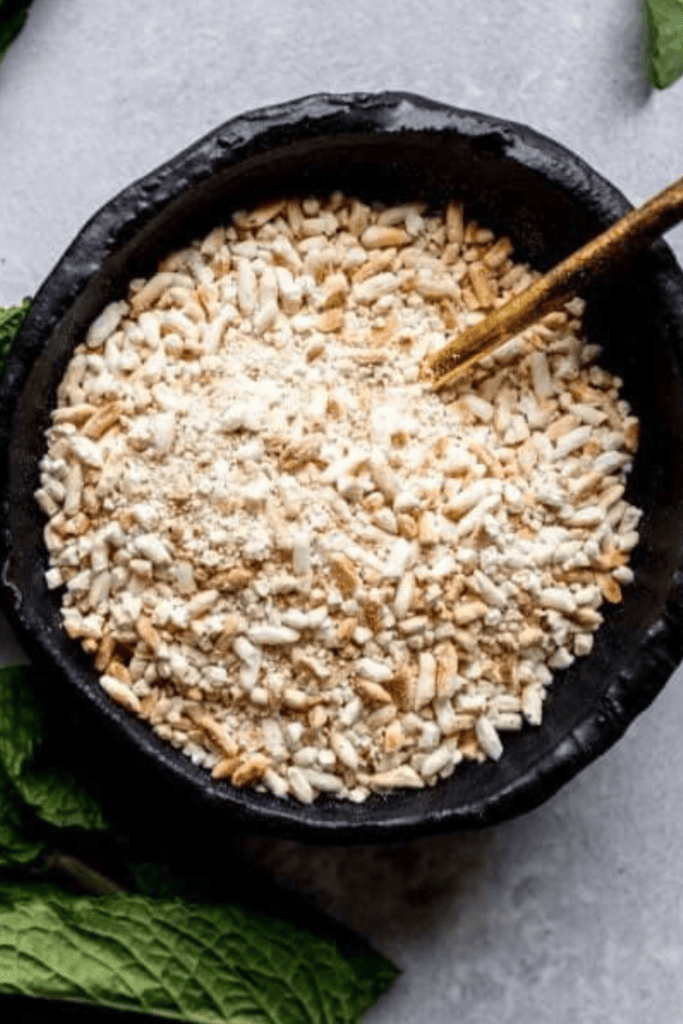 Overhead close up of toasted rice powder in black bowl.