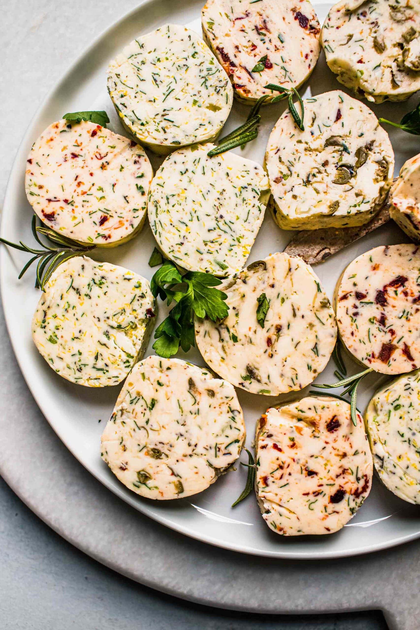 Pats of compound butter arranged on plate.