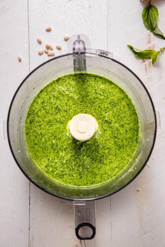 Finished arugula pesto in food processor bowl.