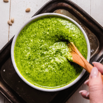 Square image of bowl of arugula pesto.