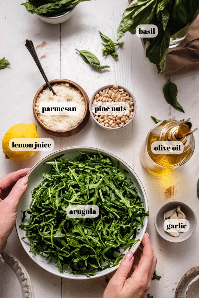 Ingredients for arugula pesto labeled on counter.