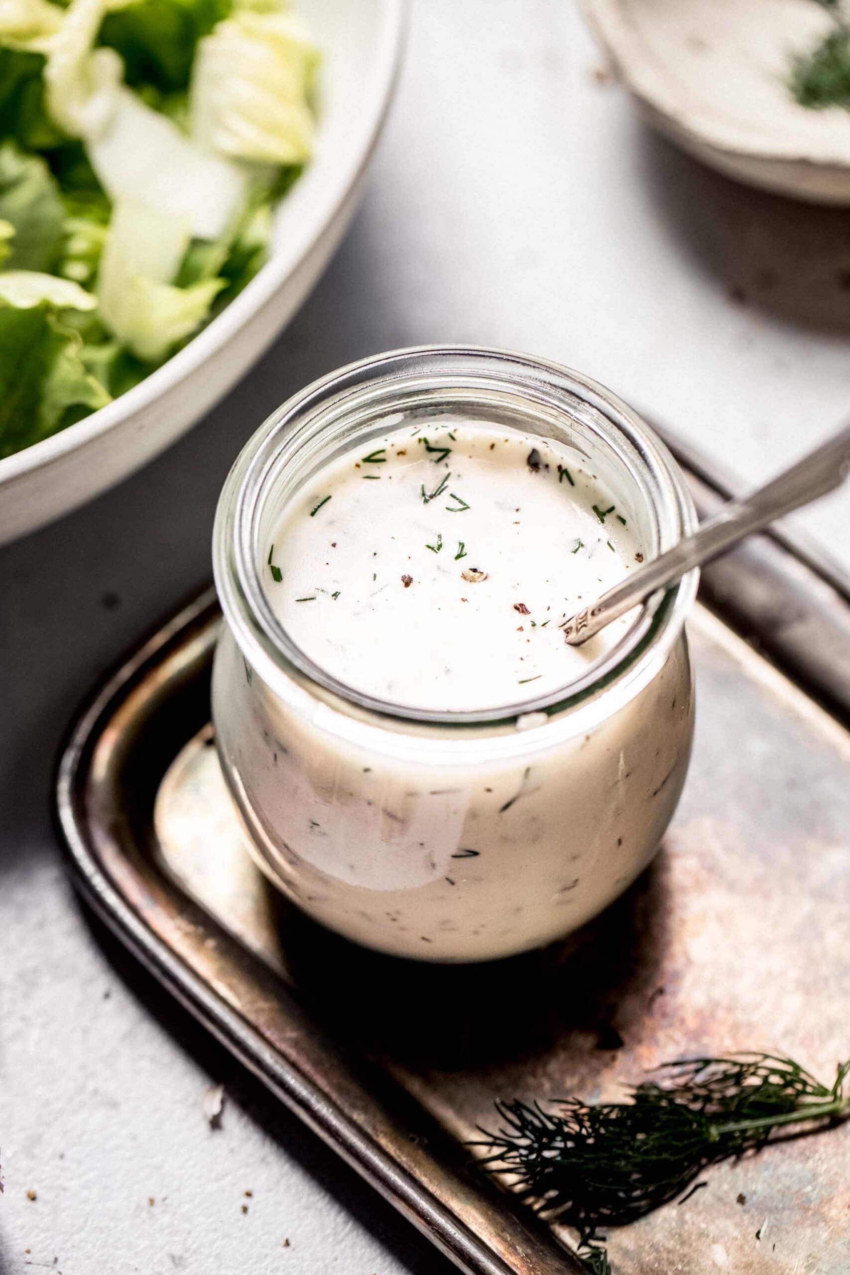 Side view of jar of creamy greek yogurt salad dressing