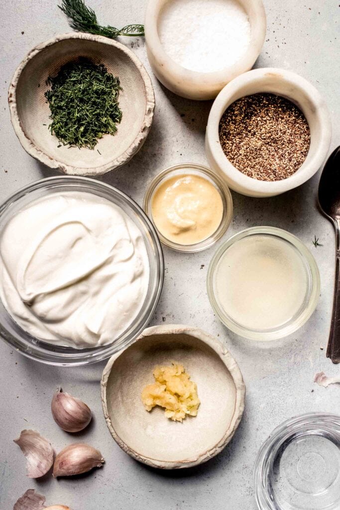 Ingredients for creamy greek yogurt dressing labeled on counter.