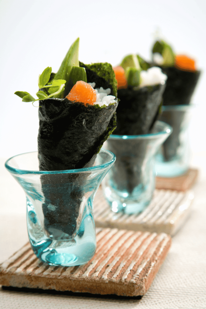 Temaki hand rolls in small glasses.
