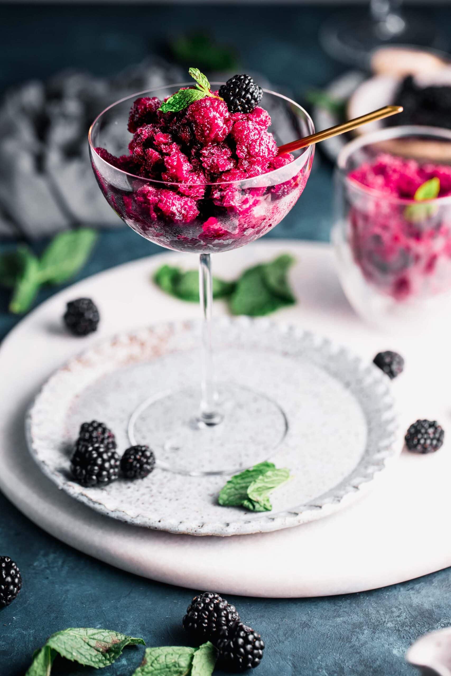 Side view of blackberry granita in champagne flute.