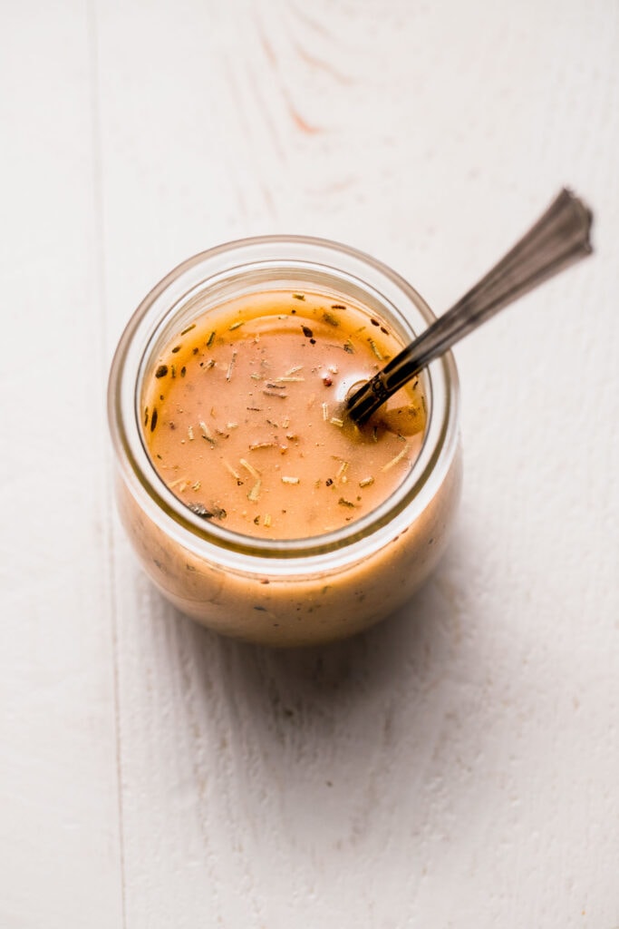 Italian dressing in small jar with spoon.