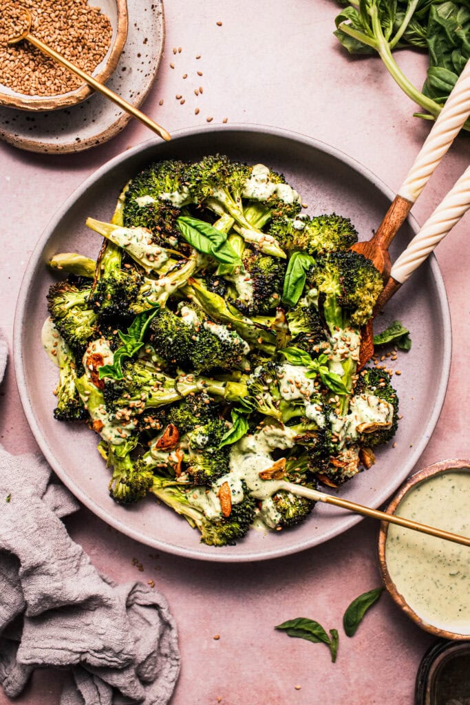 Bowl of broccoli topped with basil tahini dressing.
