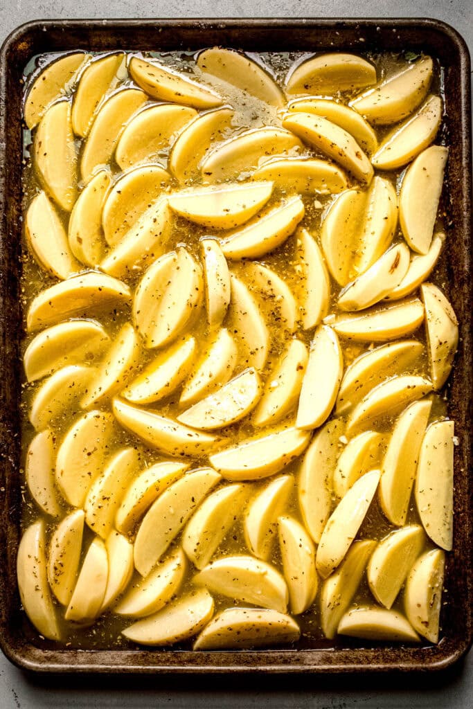 Chicken stock added to roasted potato slices.