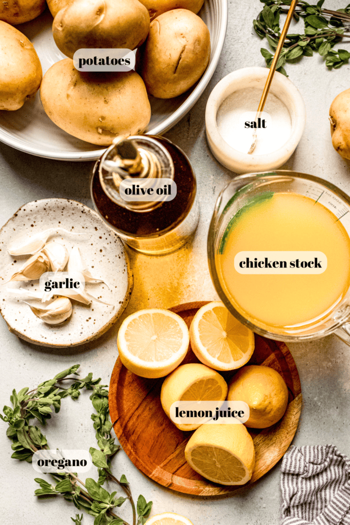 Ingredients for greek roasted potatoes labeled on counter.
