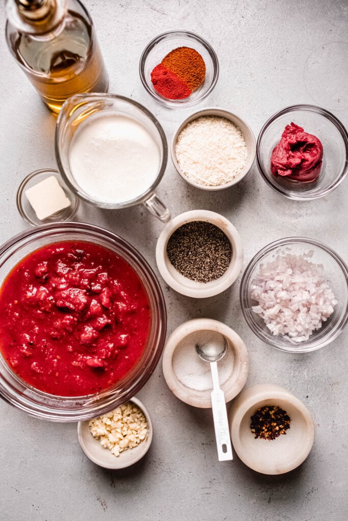 Ingredients for creamy spicy pasta labeled on counter.
